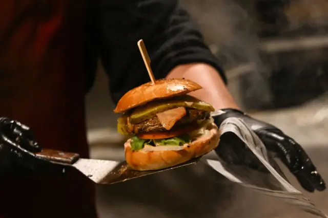 bir qarson restoranda hamburger gətirir