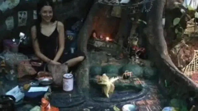 Nina mağaranın içərisində kiçik əşyalarla oturmuş görünür.