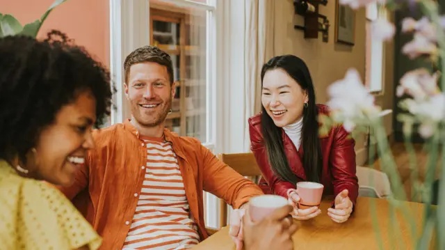 3 nəfər masa arxasında gülürlər