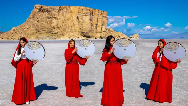 Dörd qadın qırmızı geyimlərdə qurumuş Urmiya gölünün yatağında iqlim böhranına və su qıtlığına diqqət çəkmək məqsədilə performans nümayiş etdirib.