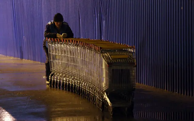 24 noyabr 2011-ci ildə çəkilmiş fotoda — Sankt-Peterburqda ərzaq mağazası yaxınlığında boş alış arabalarını toplayan Mərkəzi Asiyanın keçmiş sovet respublikalarından birindən olan əmək miqrantı görünür.